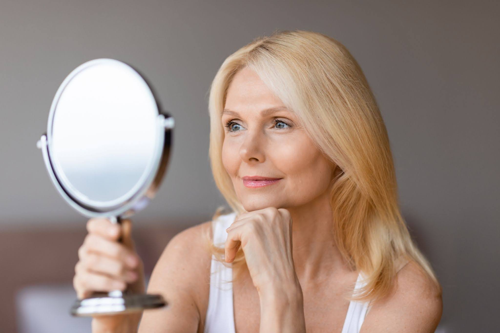 Woman Examining Skin for How to Look Younger